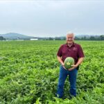 George McDonald holding a watermelon in a field