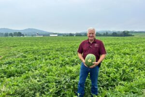 George McDonald holding a watermelon in a field
