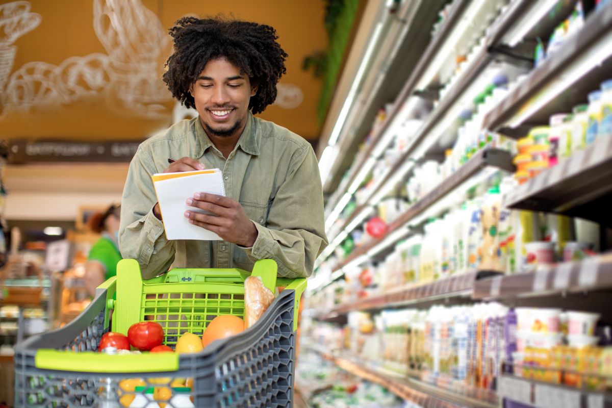 a man grocery shopping with a shopping cart
