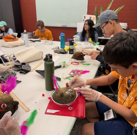 youth creating a craft around a table