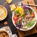 bowls of food with vegetables, hummus, and walnuts