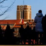 Students walk on UT campus with Ayres Hall in the background
