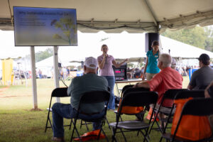 A woman with a microphone presents before a crowd