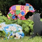 Wood cutouts in the shape of bears. Some are colorful and patterned, while one is realistically colored.