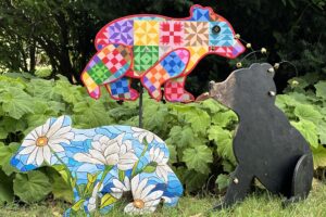Wood cutouts in the shape of bears. Some are colorful and patterned, while one is realistically colored.