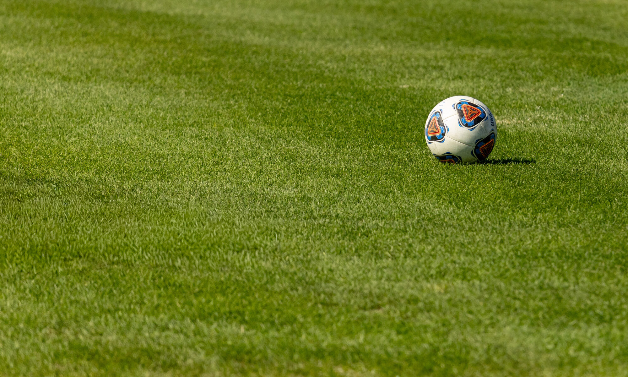A soccer ball sits on research turf grass.