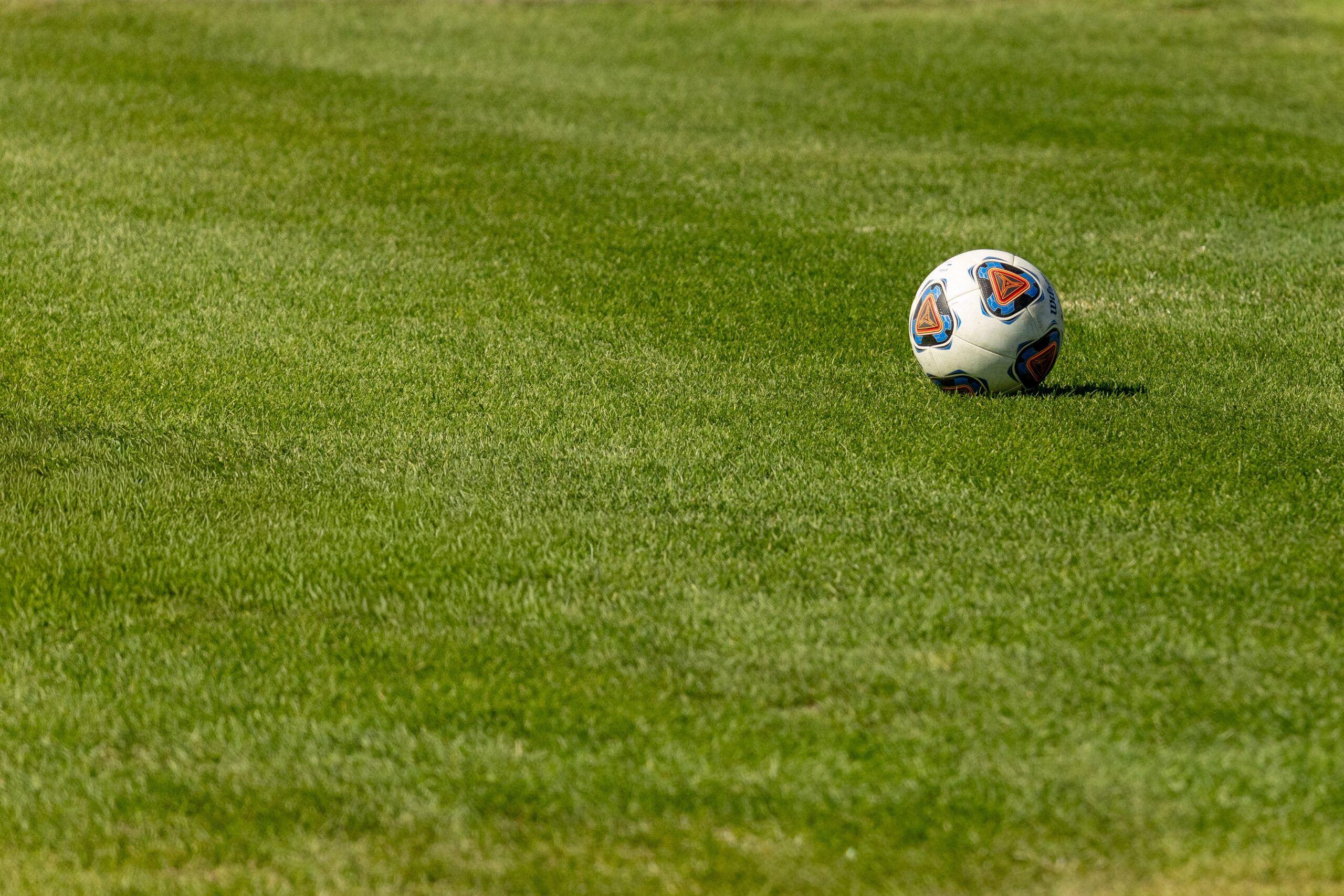 A soccer ball sits on research turf grass.