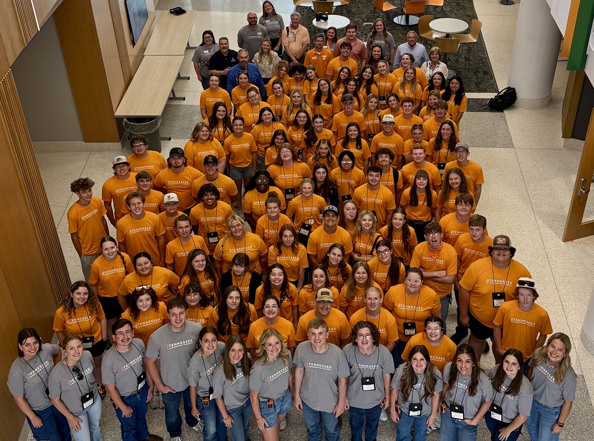 A large group of high-school students wearing orange shirts.