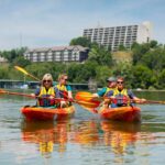Randy Boyd and Donde Plowman in kayaks on the river with two students.