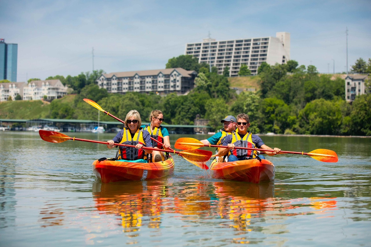 Randy Boyd and Donde Plowman in kayaks on the river with two students.