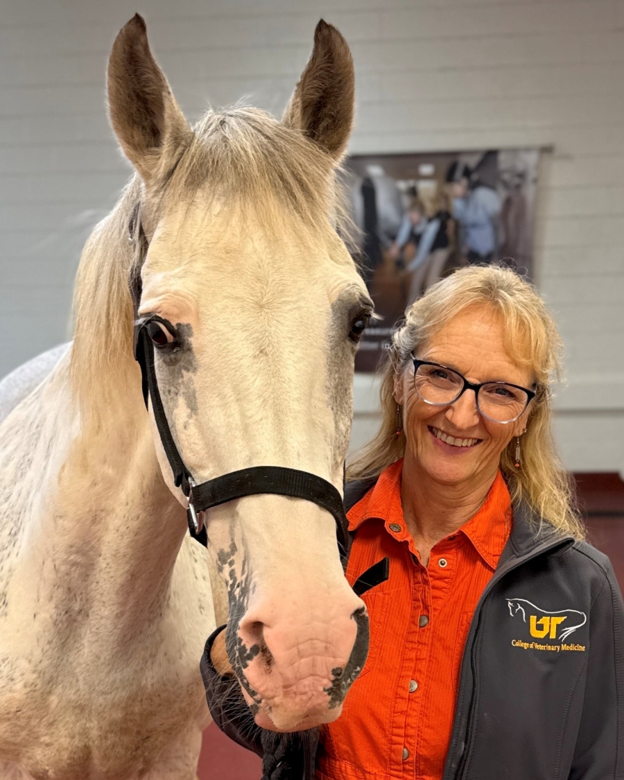 Dr. Carla Sommardahl stand with a white horse.