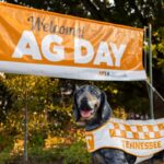 A Smokey statue in front of an orange Ag Day banner.