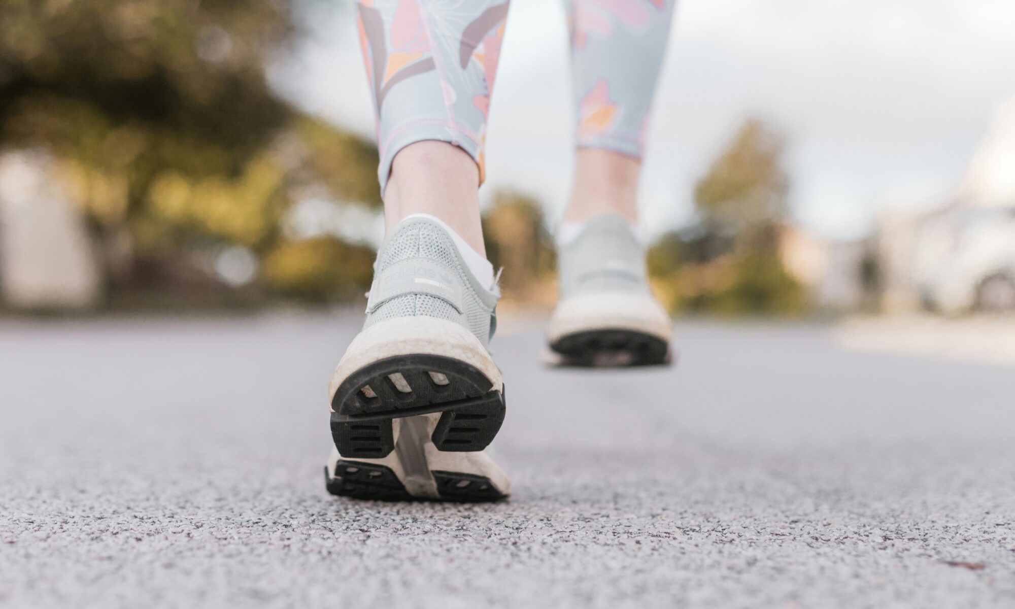 Close-up of a person's shoes as they walk on pavement